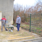 on voit un employé de la mairie faire du ciment avec une pelle et une brouette
