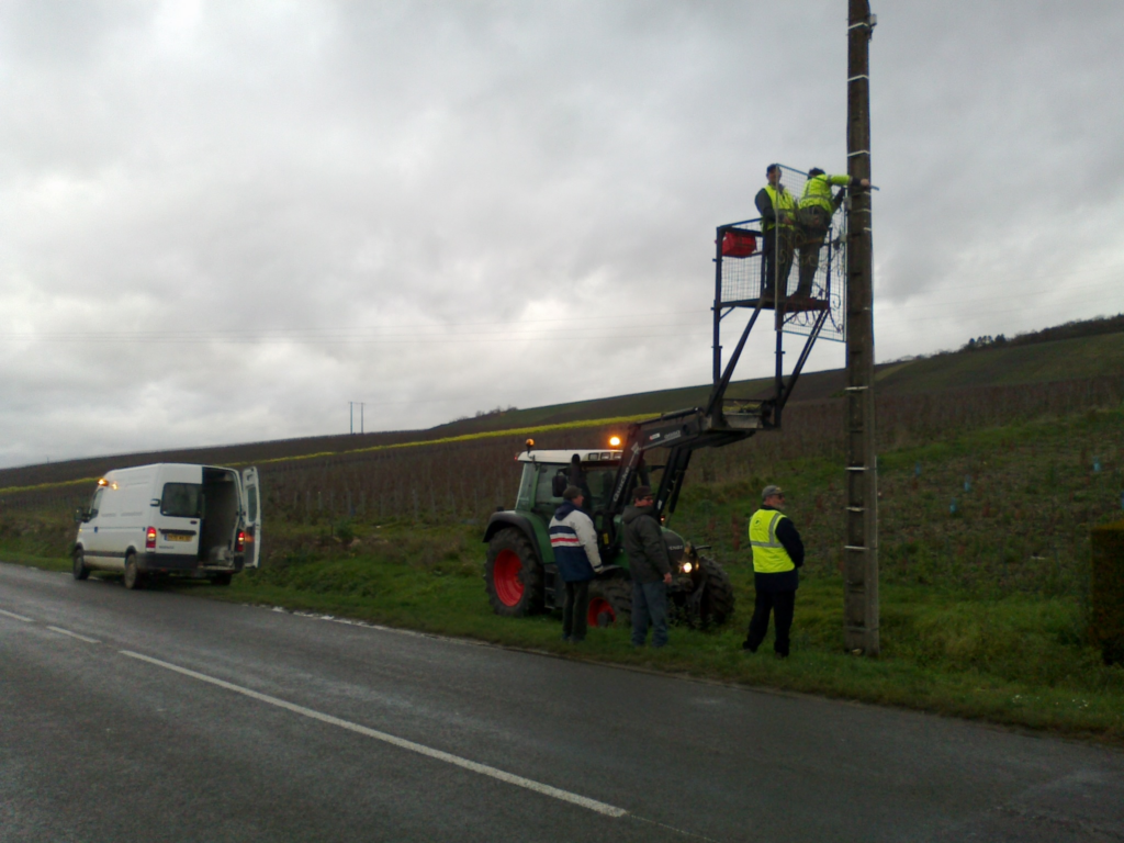 branchements électriques sur un pylône bétonné en bord de route
