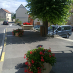 plusieurs pots de fleurs rouges sur la place du village